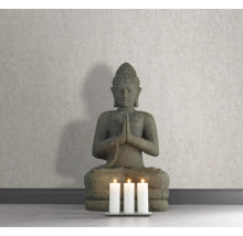 Dekorative Buddha Statue neben drei Kerzen