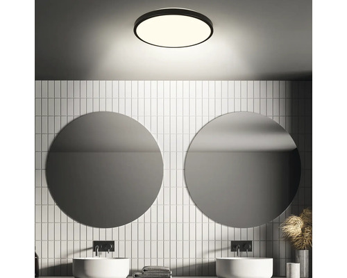 Modernes Badezimmer mit runden Spiegeln, weißen Fliesen und einer runden Deckenleuchte