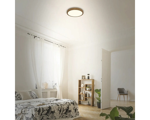 Helles Schlafzimmer mit Deckenleuchte, Bett, Regal und Vorhängen