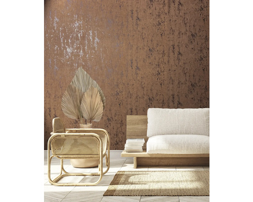 Wohnraum mit brauner Muster-Tapete, Rattan-Sessel und beigem Sofa