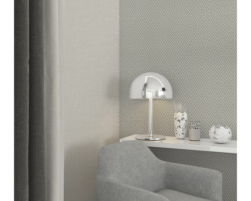 Modernes Wohnzimmer mit Sessel, Lampe und dekorativen Vasen auf einem Regal