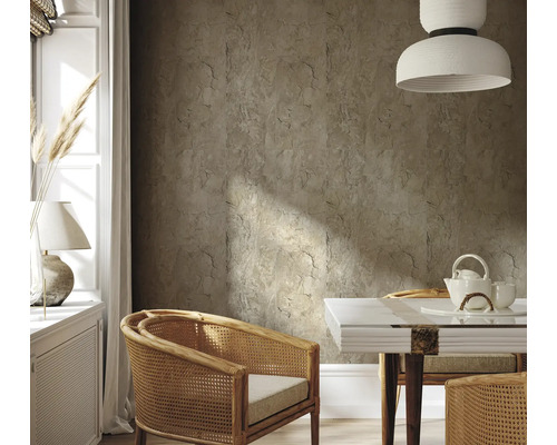 Wohnzimmer mit Wandfliesen in Steinoptik, Rattansesseln und Esstisch mit Teegeschirr.