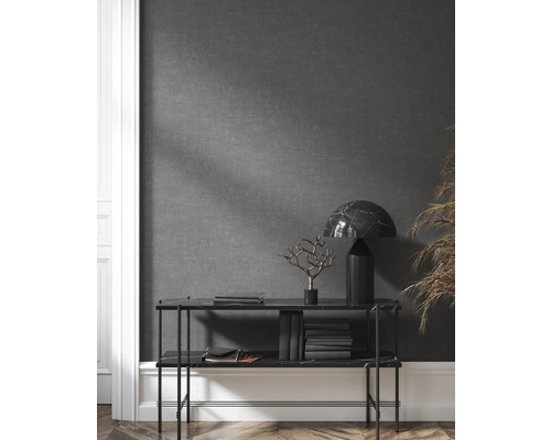 Regal mit Dekorationsgegenständen, Büchern und Lampe vor grauer Wand