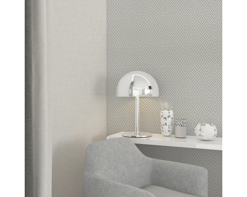 Szene mit Sessel, Tischleuchte und gemusterter Tapete