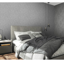 Schlafzimmer mit grauer Strukturtapete, Bett und Nachttisch