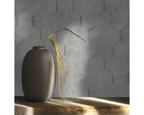 Dekorative graue Vase mit Weizenähren vor einer Wand mit sechseckigen Betonfliesen