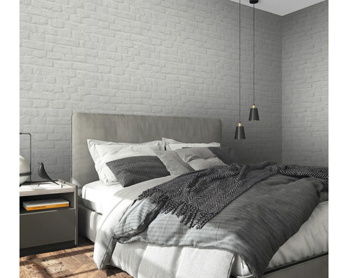 Schlafzimmer mit Bett, Nachttisch und Wandtapete im Mauerwerkdesign.
