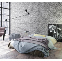 Helles Schlafzimmer mit Bett, Wandleuchte und Backstein Tapete