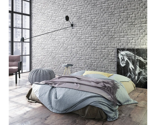 Helles Schlafzimmer mit Bett, Wandleuchte und Backstein Tapete