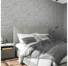 Schlafzimmer mit Bett, Nachttisch und grauer Backstein Tapete
