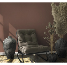 Zimmer mit Sessel, dekorativen Vasen und Ziergräsern für eine wohnliche Atmosphäre