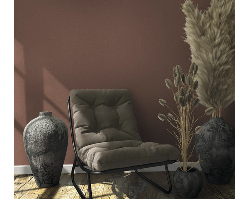 Zimmer mit Sessel, dekorativen Vasen und Ziergräsern für eine wohnliche Atmosphäre