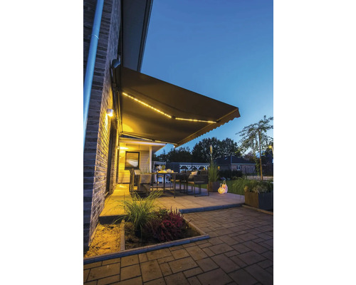 Terrasse mit Markise und Sitzgruppe am Abend