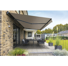 Ausgefahrene Gelenkarmmarkise über einer Terrasse mit Tisch und Stühlen.