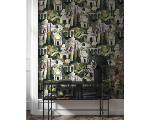 Zimmer mit einer gemusterten Tapete, die eine Landschaft mit Bäumen und kleinen Gebäuden darstellt. Eine Konsole steht vor der Tapete.