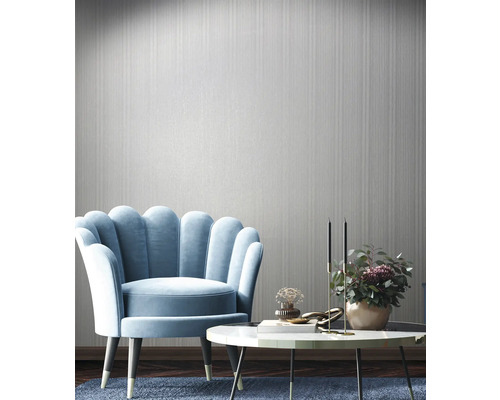 Einrichtungsbeispiel mit Sessel, Tisch und Wandtapete in einem hellen Raum.