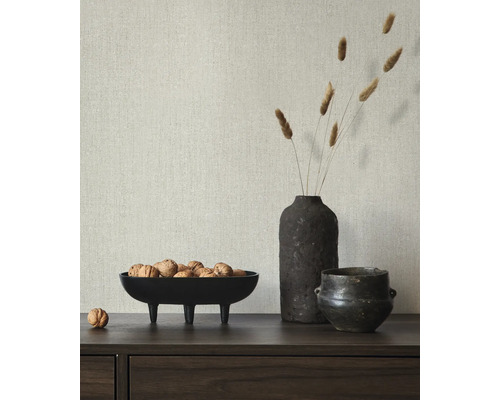 Dekorative Szene mit einer Schale mit Nüssen, einer Vase mit Gräsern und einem kleinen Topf auf einem Sideboard