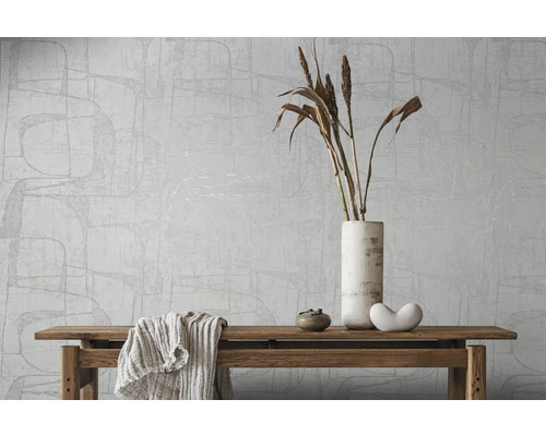 Tapete mit abstraktem Muster, dekoriert mit Vase, Trockenblumen, Dekoration und einer Decke auf einer Holzbank