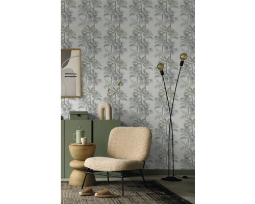 Wohnzimmer mit Palmenmuster Tapete, Sessel und Stehlampe.