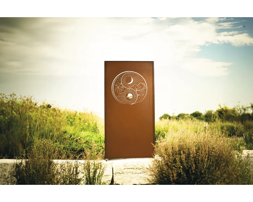 Dekorative Gartenstele mit Yin-und-Yang-Motiv in einem Garten