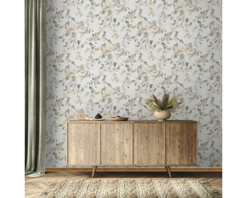 Szene mit einem hölzernen Sideboard vor einer floralen Tapete und einem Teppich.