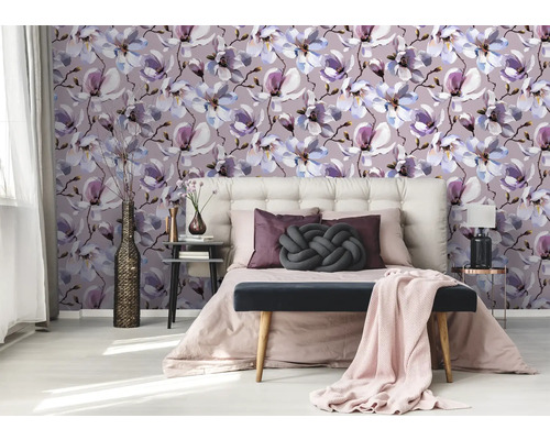 Schlafzimmer mit Magnolienmuster Tapete, Bett und Nachttischen.