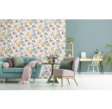 Wohnzimmer mit Sofa, Sessel, Schreibtisch und floraler Tapete