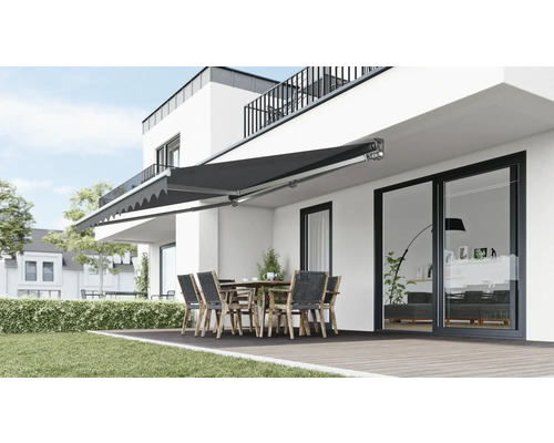 Terrasse mit Markise, Tisch und Stühlen an modernem Haus
