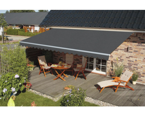 Terrasse mit Markise, Tisch, Stühlen und Liege vor einem Haus