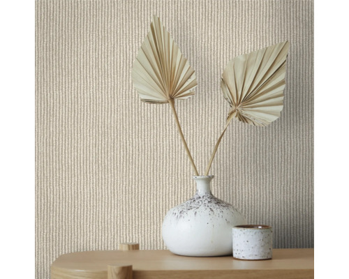 Nahaufnahme einer Wand mit Strickmuster-Tapete, dekoriert mit einer Vase und getrockneten Palmenblättern auf einem Holztisch.