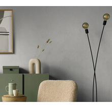 Wohnraum mit grauer Tapete, Stehlampe und grünen Möbeln für eine gemütliche Atmosphäre