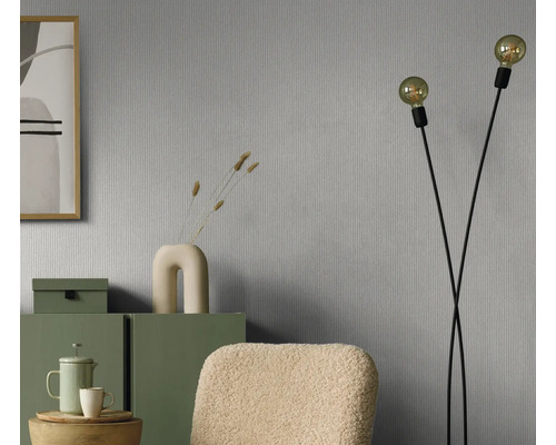 Wohnraum mit grauer Tapete, Stehlampe und grünen Möbeln für eine gemütliche Atmosphäre