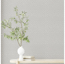 Nahaufnahme einer strukturierten Tapete mit Pflanzenarrangement auf einem Tisch