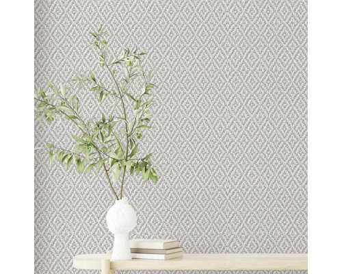 Nahaufnahme einer strukturierten Tapete mit Pflanzenarrangement auf einem Tisch