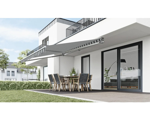 Ausgefahrene Gelenkarmmarkise über einer Terrasse mit Gartentisch und Stühlen