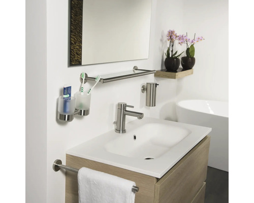 Badezimmer mit Waschbecken, Spiegel, Handtuchhalter, Seifenspender und Zahnputzbecher