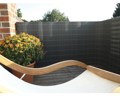 Balkonsichtschutz mit orangenfarbener Chrysantheme im Topf auf Holzboden