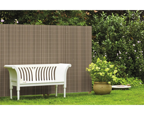 Gartenszene mit Sichtschutzzaun, Gartenbank und bepflanztem Topf