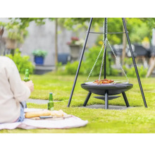 Schwenkgrill im Garten mit Person im Hintergrund