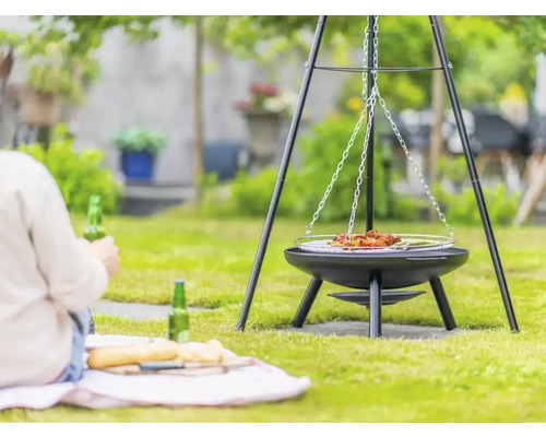 Schwenkgrill im Garten mit Person im Hintergrund