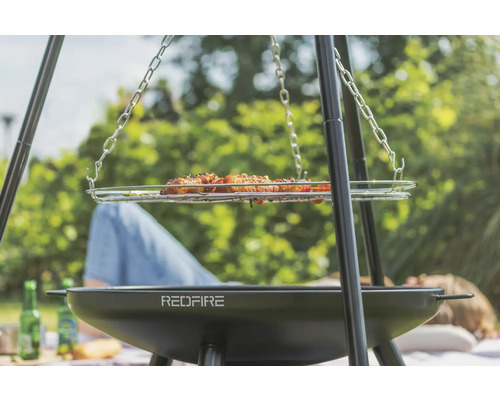Dreibeingrill mit Grillgut und RedFire Logo für Outdoor Grillvergnügen