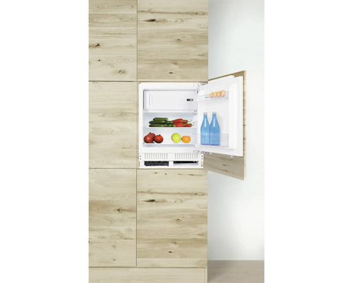 Eingebauter Kühlschrank in Holzoptik mit geöffneter Tür, gefüllt mit Lebensmitteln.