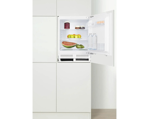 Eingebauter Kühlschrank mit geöffneter Tür, gefüllt mit Lebensmitteln in weißer Küche