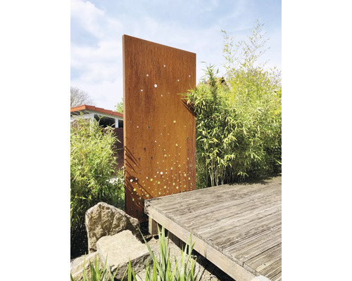 Gartenszene mit rostfarbener Sichtschutzwand aus Metall und Holzterrasse