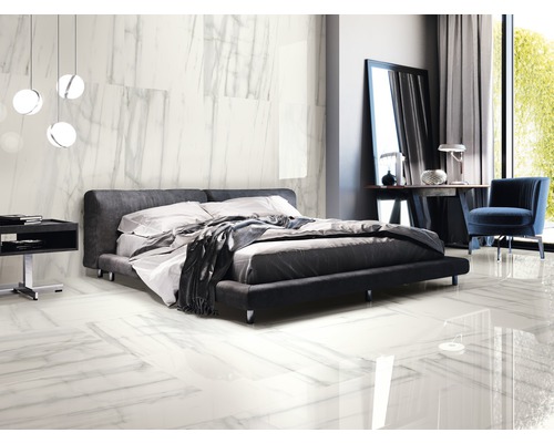 Helles Schlafzimmer mit Doppelbett, Nachttisch, Stuhl und Bodenfliesen in Marmoroptik