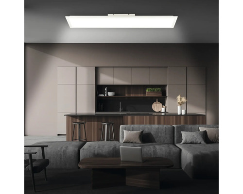 Modernes Wohnzimmer mit Küchenzeile, beleuchtet durch eine rechteckige Deckenleuchte