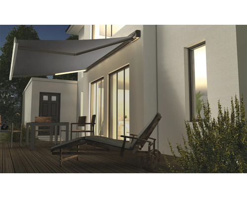 Terrasse mit ausfahrbarer Markise und Gartenmöbeln am Haus