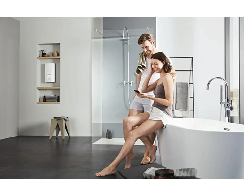 Helles Badezimmer mit Badewanne, Dusche, Durchlauferhitzer und Paar