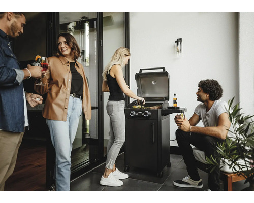 Personen grillen mit einem Gasgrill auf einer Terrasse