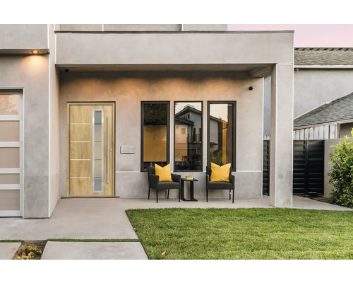 Modernes Haus mit Haustür, Fenstern und Sitzbereich im Freien